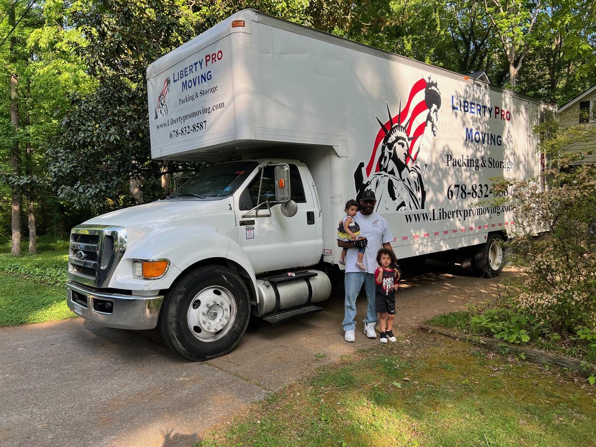 Ashauntai with his kids in front of a Liberty Pro Moving truck in Lawrenceville