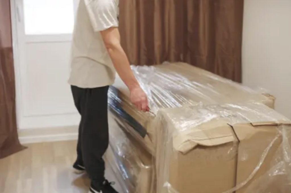 Professional movers wrapping furniture during Loganville Georgia move | Lawrenceville Moving Company | LIBERTY PRO MOVING Professional movers wrapping furniture during Loganville Georgia move