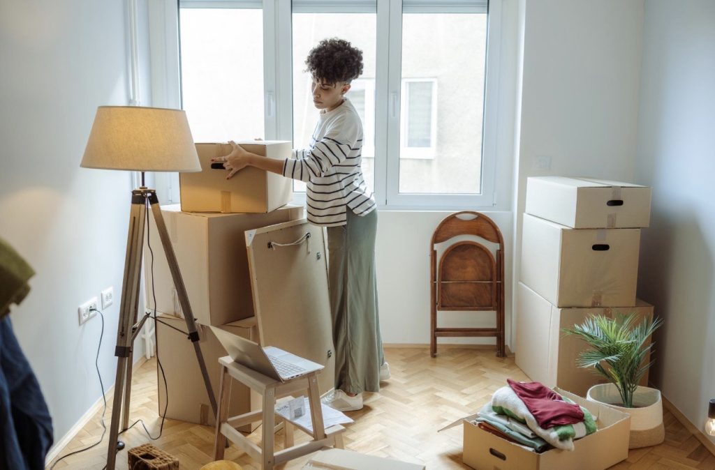 Homeowners organizing boxes in living room after moving | Lawrenceville Moving Company | LIBERTY PRO MOVING Homeowners organizing boxes in living room after moving